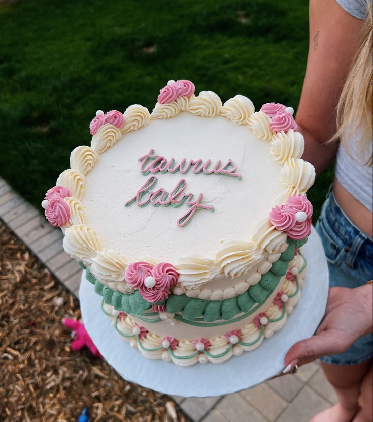 a woman holding a cake with the words happy birthday written on it in frosting