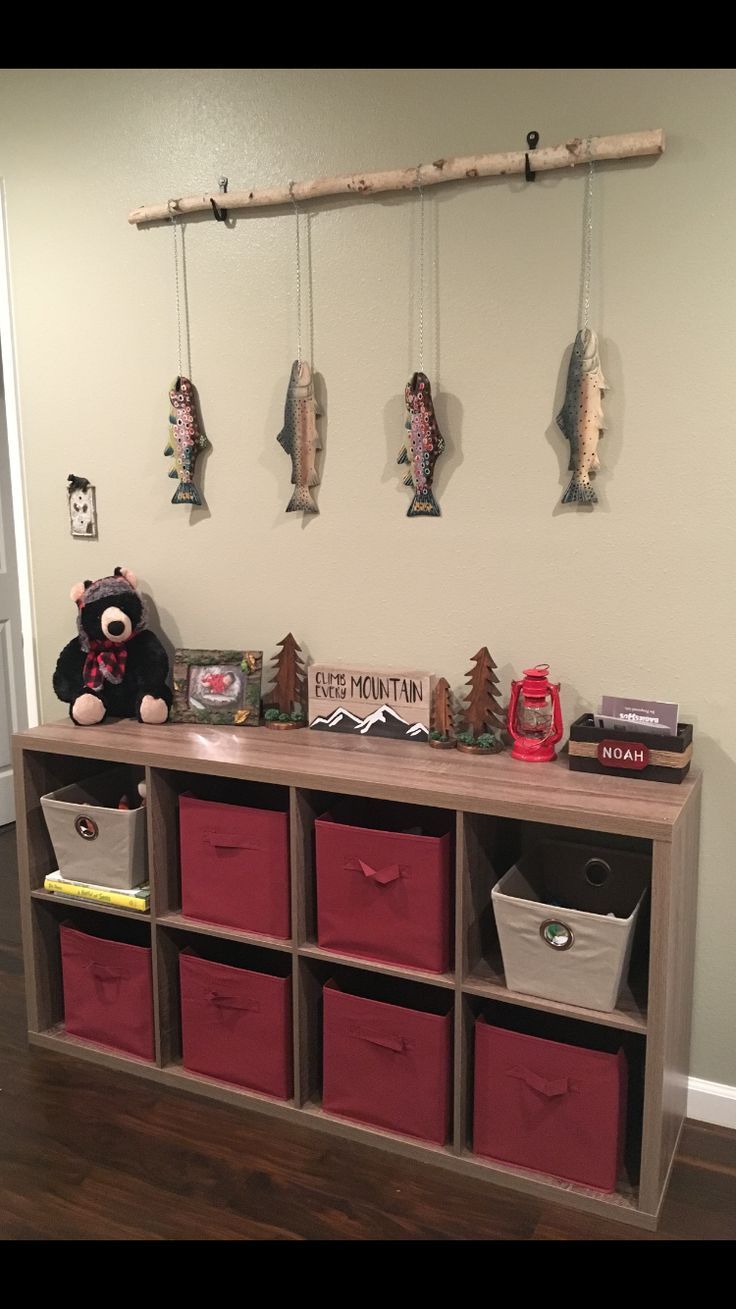 there is a shelf with baskets and stuffed animals on the top, along with other toy bins