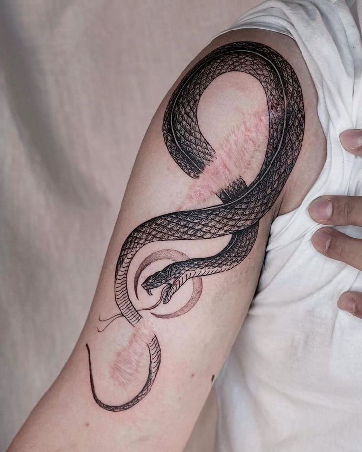 a man with a snake tattoo on his arm