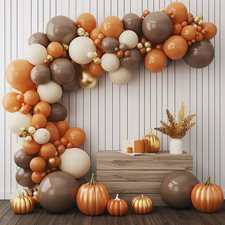 the balloon arch is decorated with pumpkins and gold balloons, along with other decorations