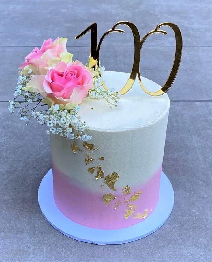 a white cake with pink and gold frosting