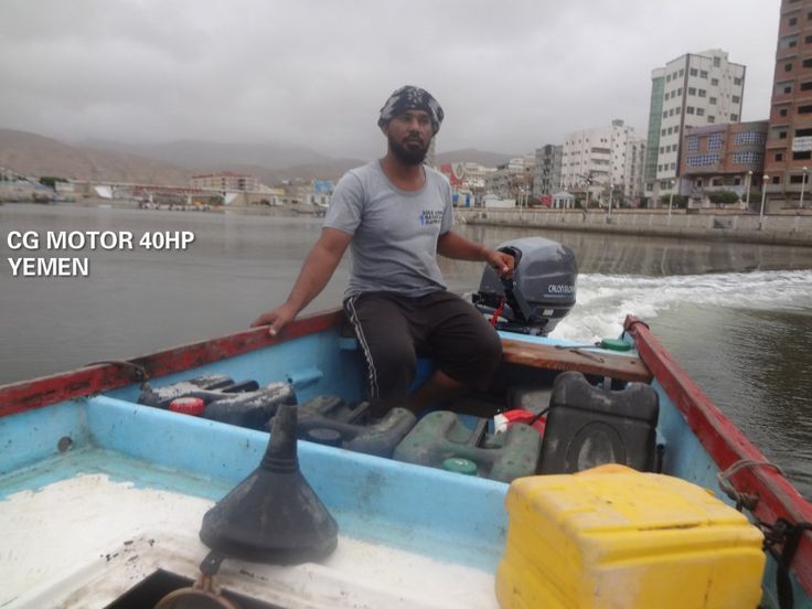 a man sitting in the back of a blue boat