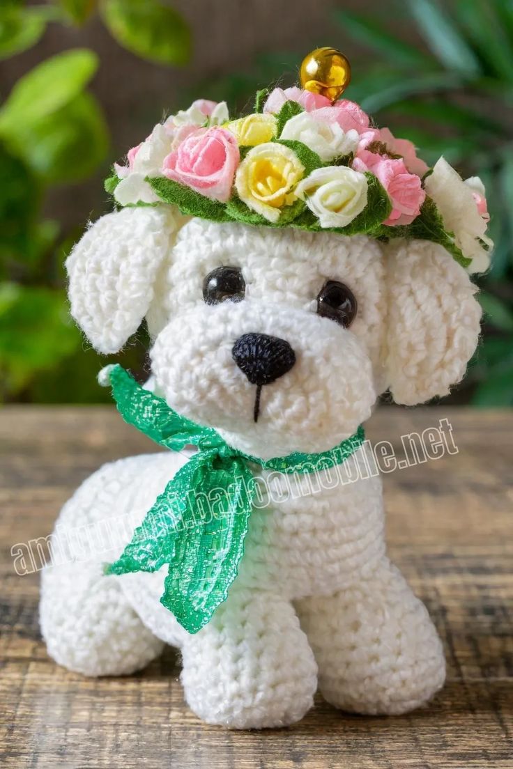 a crocheted dog with a flower crown on it's head sitting on a table