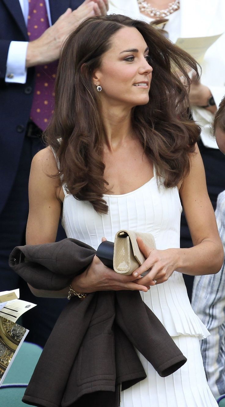 a woman in a white dress holding a purse