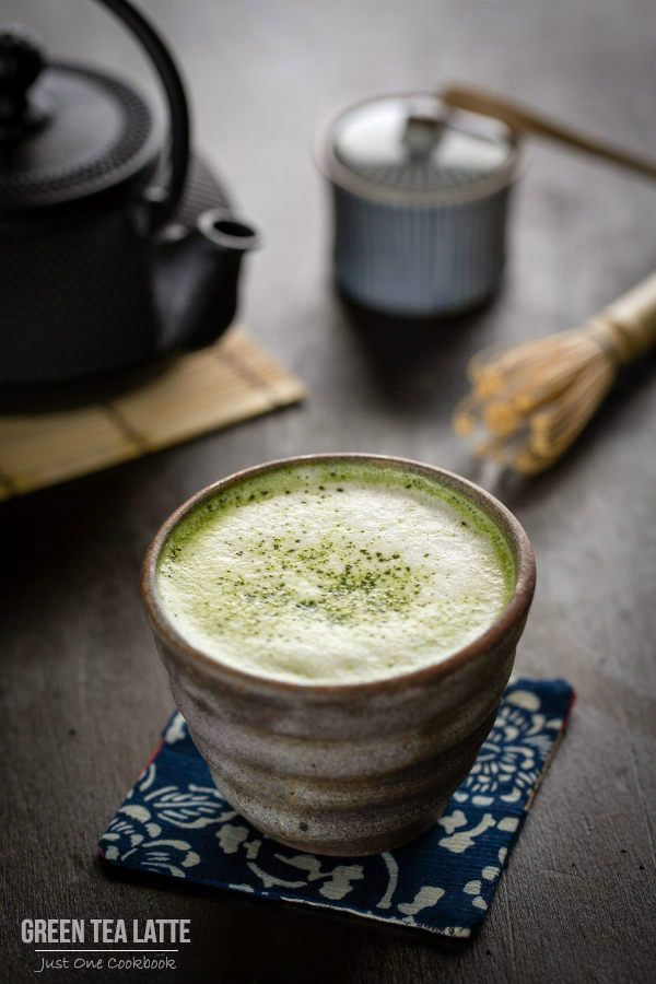 a cup of green tea sitting on top of a blue and white napkin