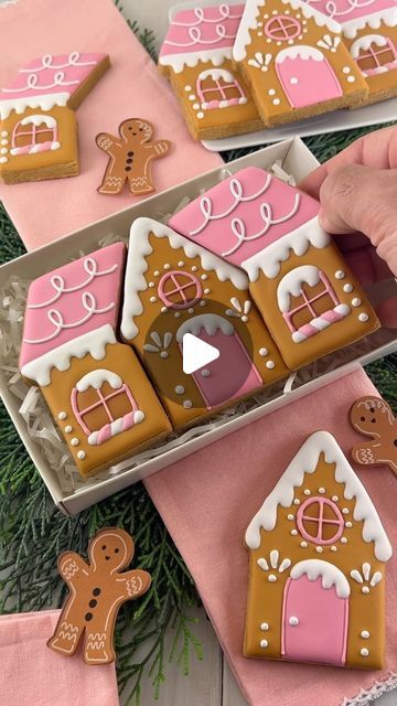 someone is decorating gingerbread houses with icing