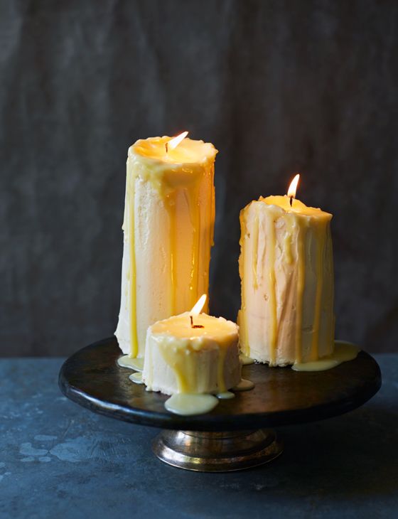 two candles are sitting on a black plate