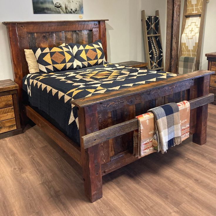 a bed sitting on top of a wooden floor next to a dresser and mirror in a room