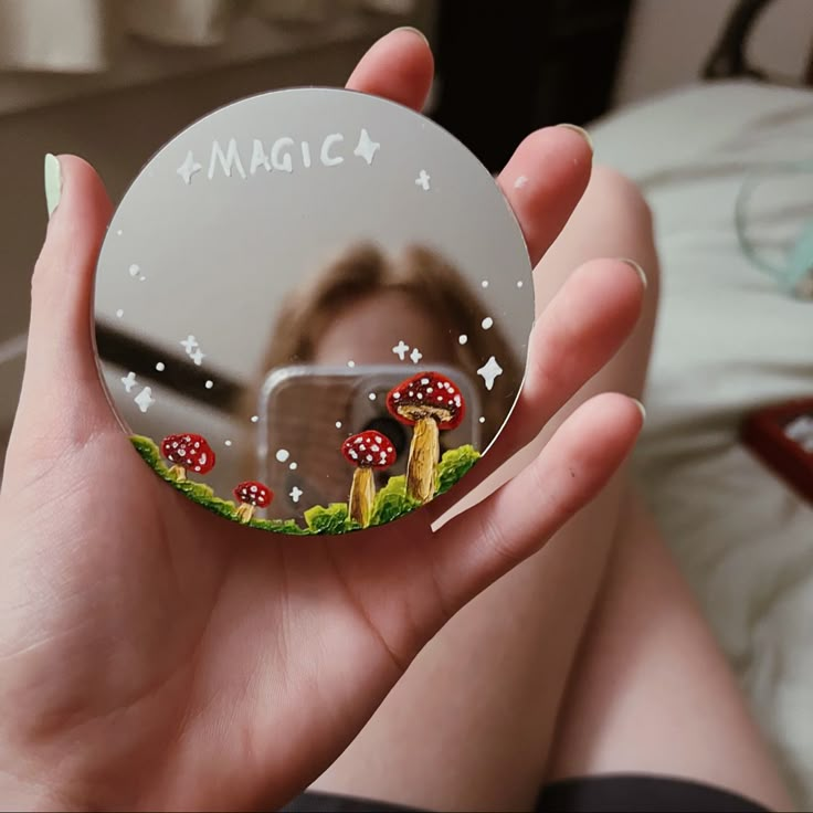 a person holding up a magnet with mushrooms on it in front of a woman's face