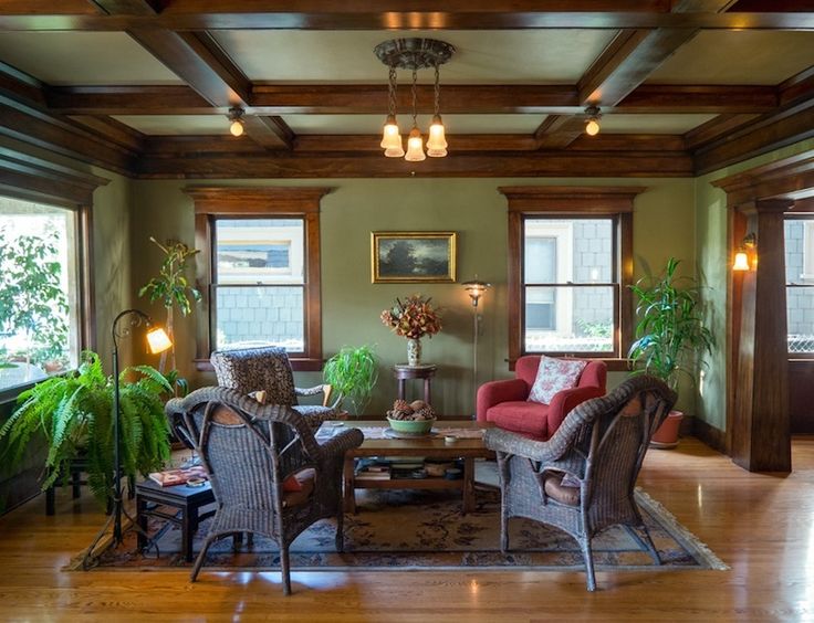 a living room filled with lots of furniture next to two large windows and wooden floors