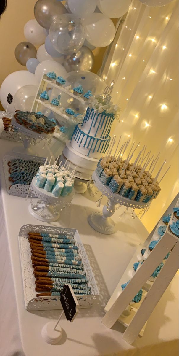 a table topped with lots of blue and white desserts