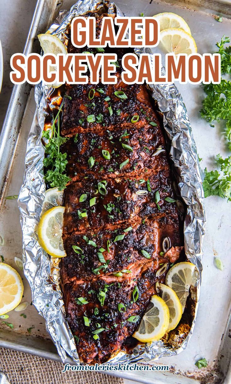 grilled sockeye salmon in foil with lemons and parsley on the side