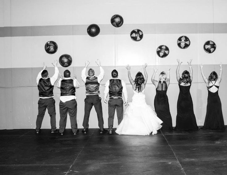 a group of people standing next to each other in front of a wall with plates on it