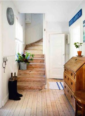 a wooden staircase leading up to a white door