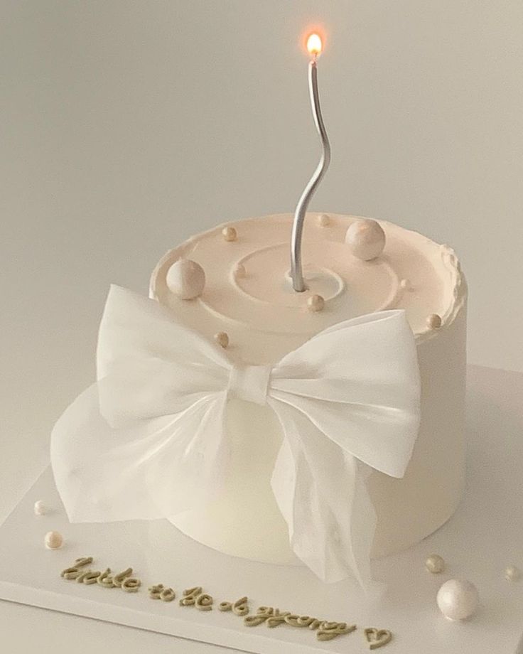 a birthday cake with a white bow on it