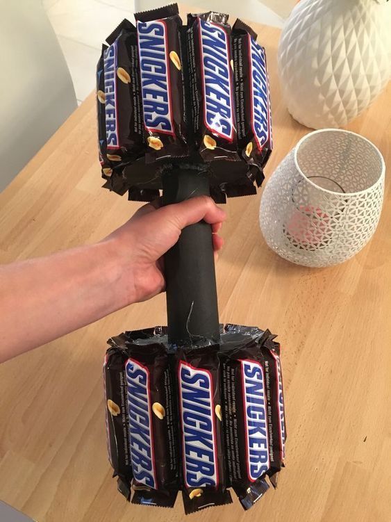 a person holding up some chocolate bars on top of a table