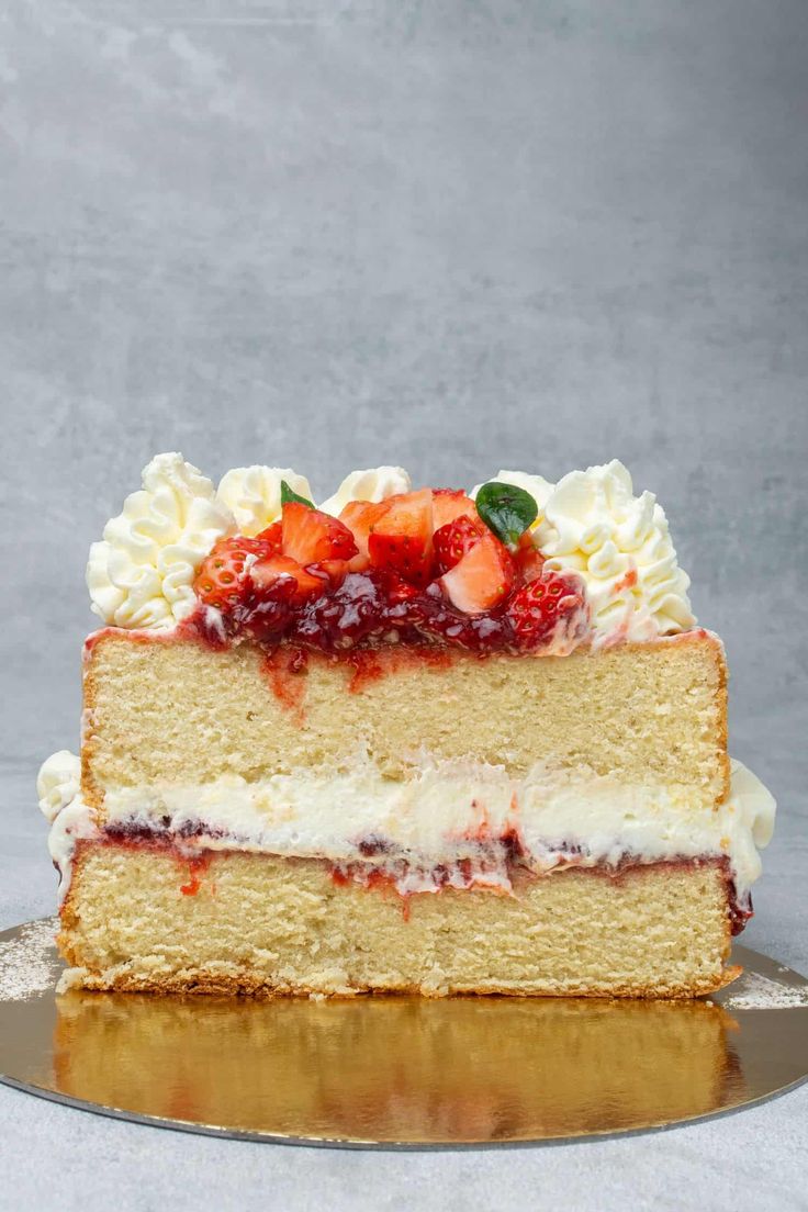 a slice of cake with strawberries on top and the words, most amazing victoria sponge cake