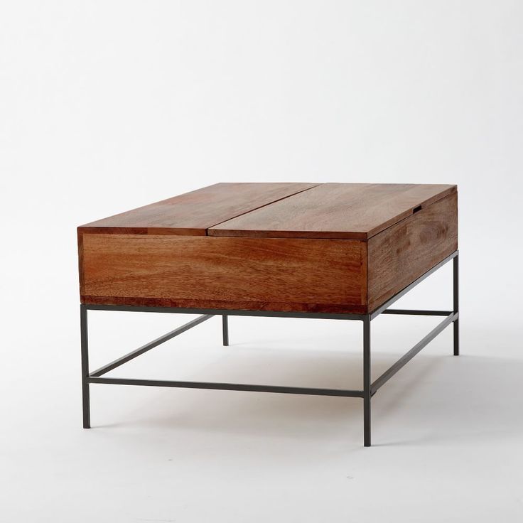 a wooden table with metal legs and a drawer on the top that is open to reveal a piece of furniture