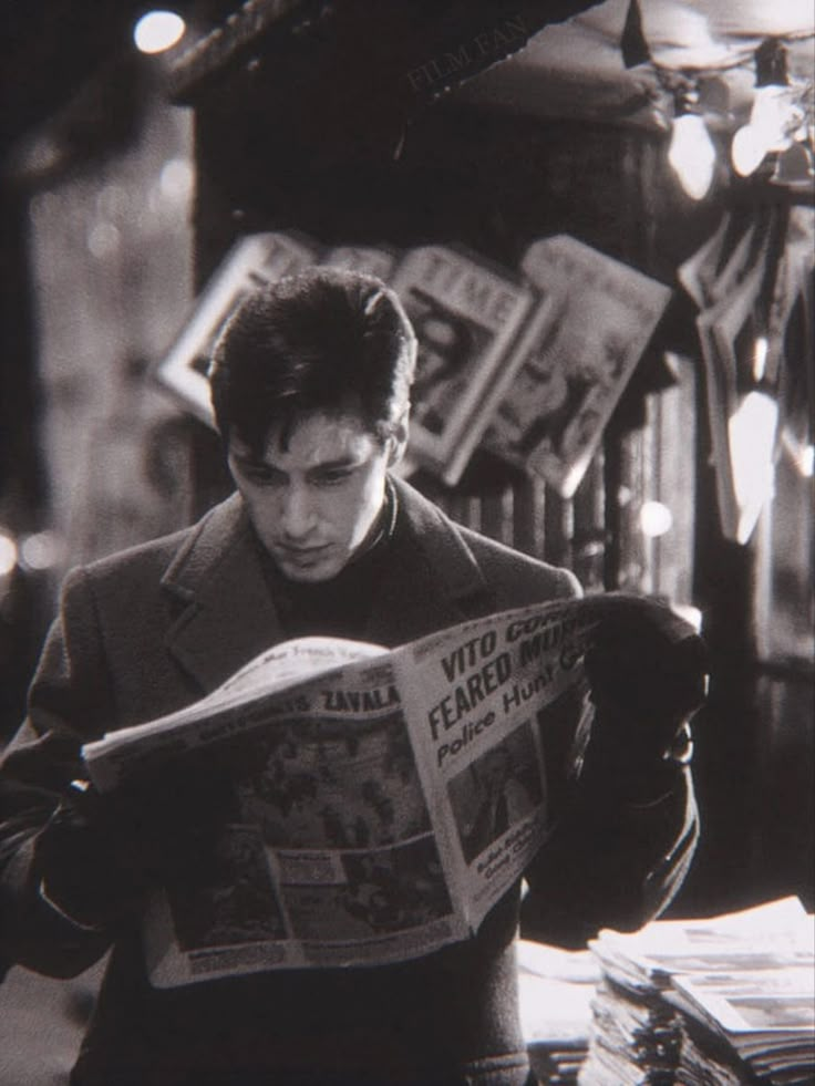 a man reading a newspaper while standing in front of a store