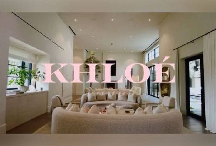 a living room filled with lots of furniture next to a window covered in pink lettering