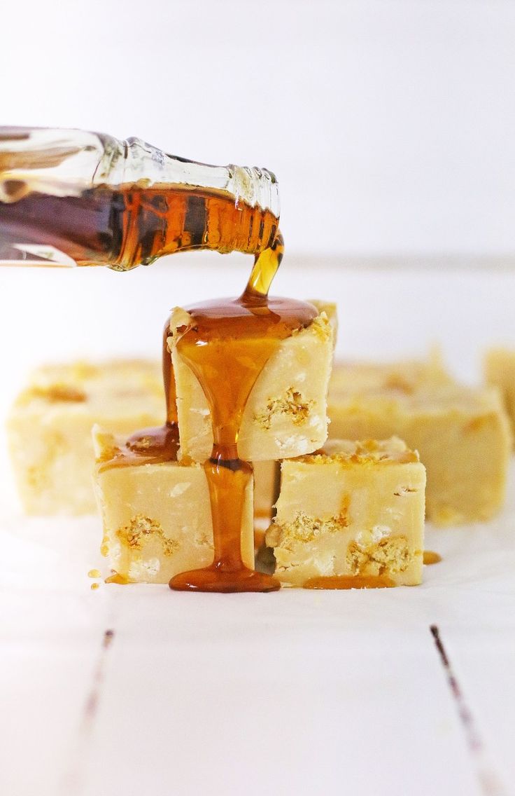 honey being poured onto pieces of cheesecake with caramel sauce on the top and bottom