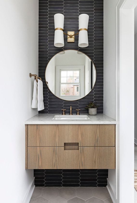 a bathroom with a sink, mirror and two lights on the side of the wall