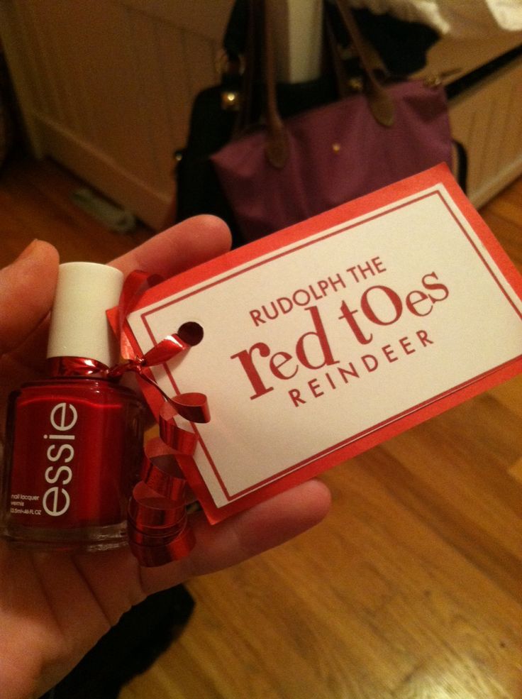 a person holding up a red toe nail polish in front of a purple handbag