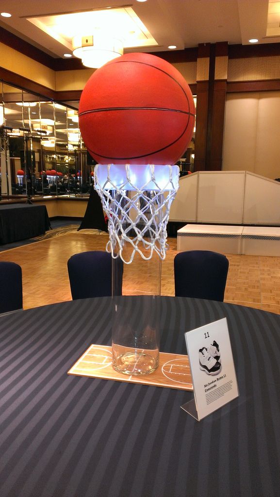 a basketball is on top of a basket in the middle of a banquet room table