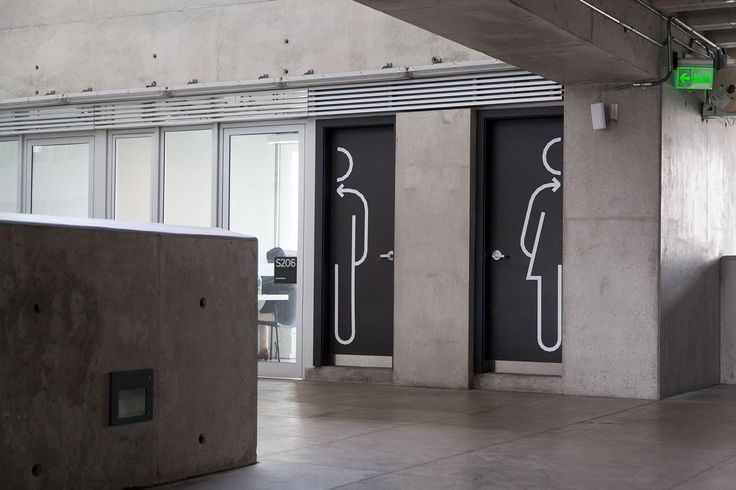 two black doors with white stickers on them in an empty room next to windows