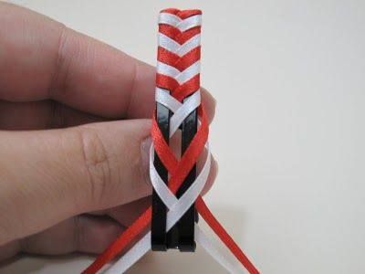 a hand holding a red and white piece of string