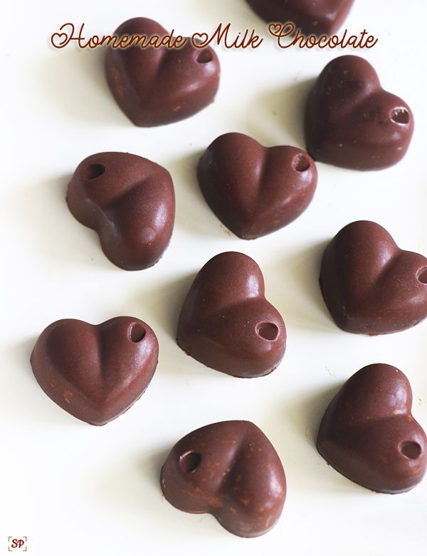 chocolate heart shaped candies are arranged on a white surface with the words homemade milk chocolate written above them