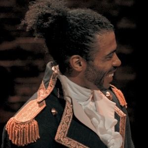 a man with dreadlocks is smiling at someone