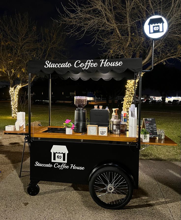 an outdoor coffee cart with lights on the side and a sign for succolo coffee house