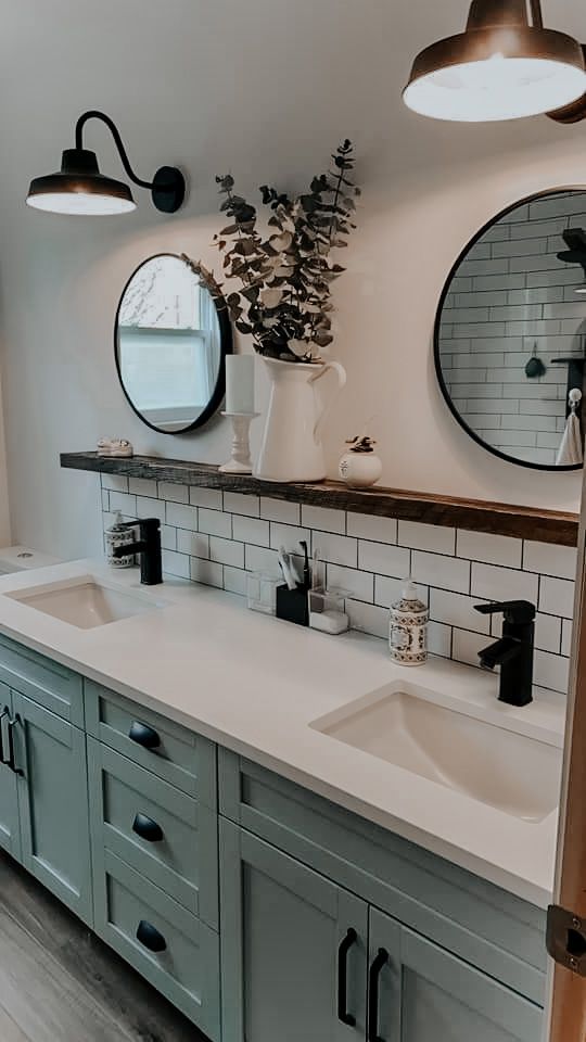 a bathroom with two sinks, mirrors and lights on the wall next to each other