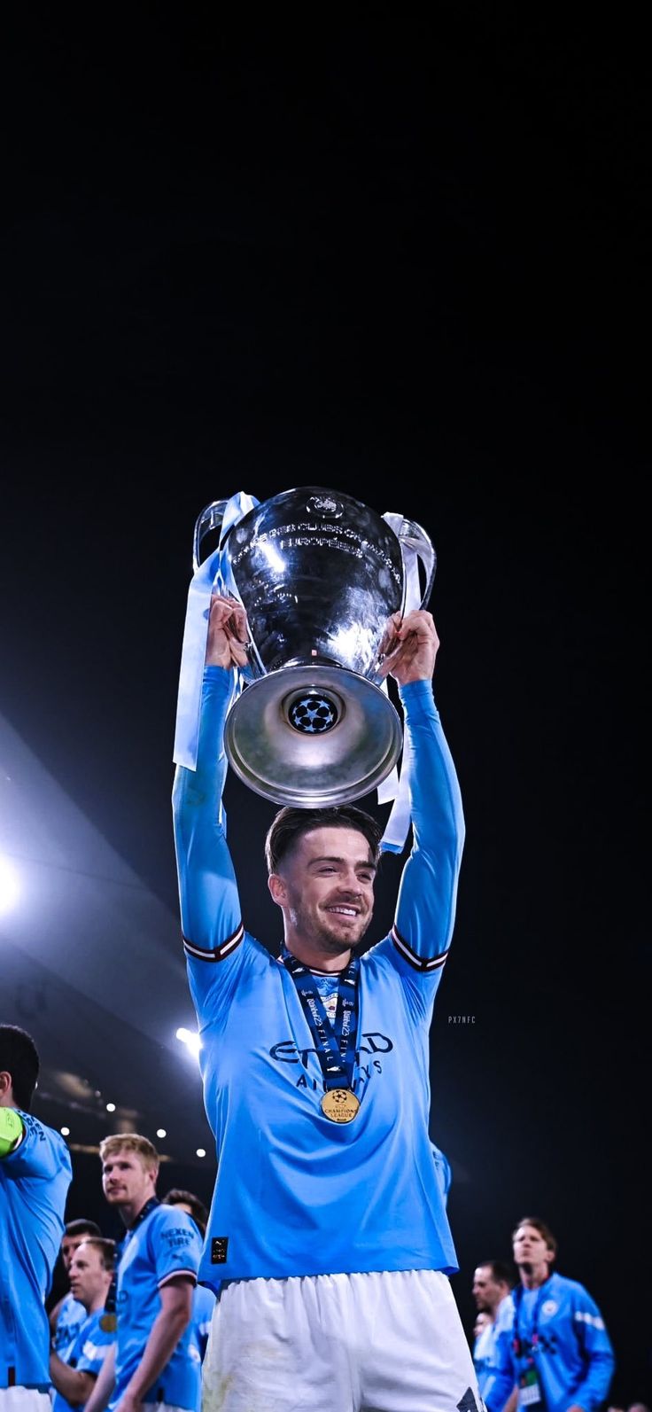 a man holding up a trophy on top of his head in front of other men