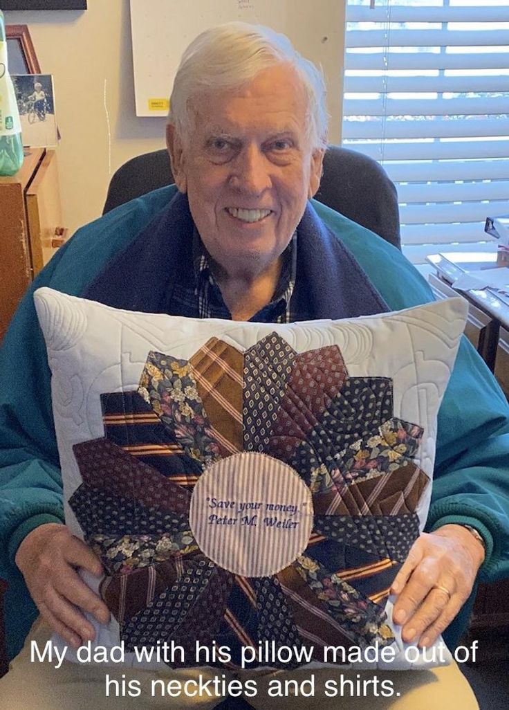 an older man holding up a pillow that has been made to look like a flower