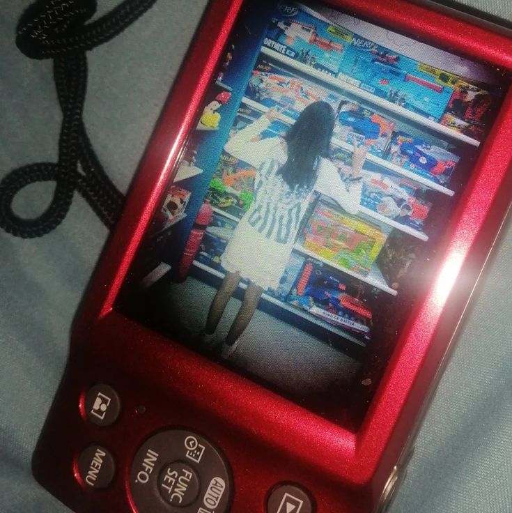 a red cell phone sitting on top of a bed