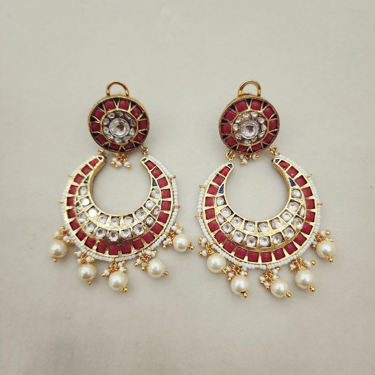 Adorn yourself with these Coral & Kundan Chandbali Earrings, crafted in gold foil. Featuring coral accents paired with Kundan work, these chandbalis blend traditional craftsmanship with timeless elegance. Perfect for special occasions, they add a regal touch to any ensemble. Length: 3" to 3.5" Material: 24Kt gold foil, lac Stones: Kundans, semi precious corals, semi precious pearls Kundan Chandbali, Coral Accents, Kundan Work, Chandbali Earrings, Pin Pendant, 24kt Gold, Pendant Rings, Natural Beads, Gold Foil