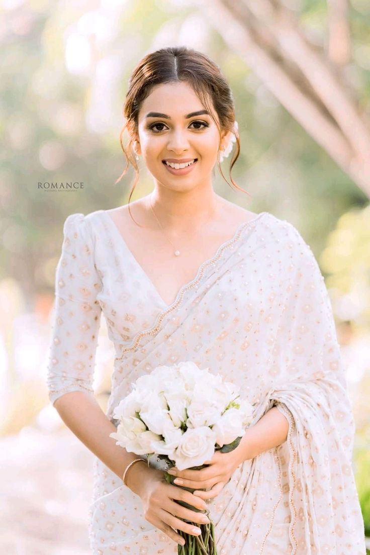 a woman holding a bouquet of white flowers