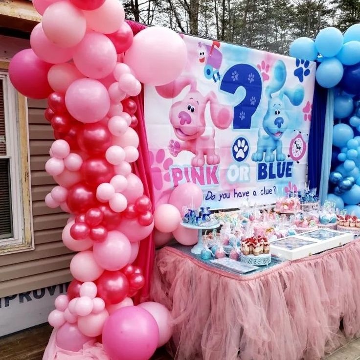 a pink and blue birthday party with balloons on the side of the table, including an animal theme