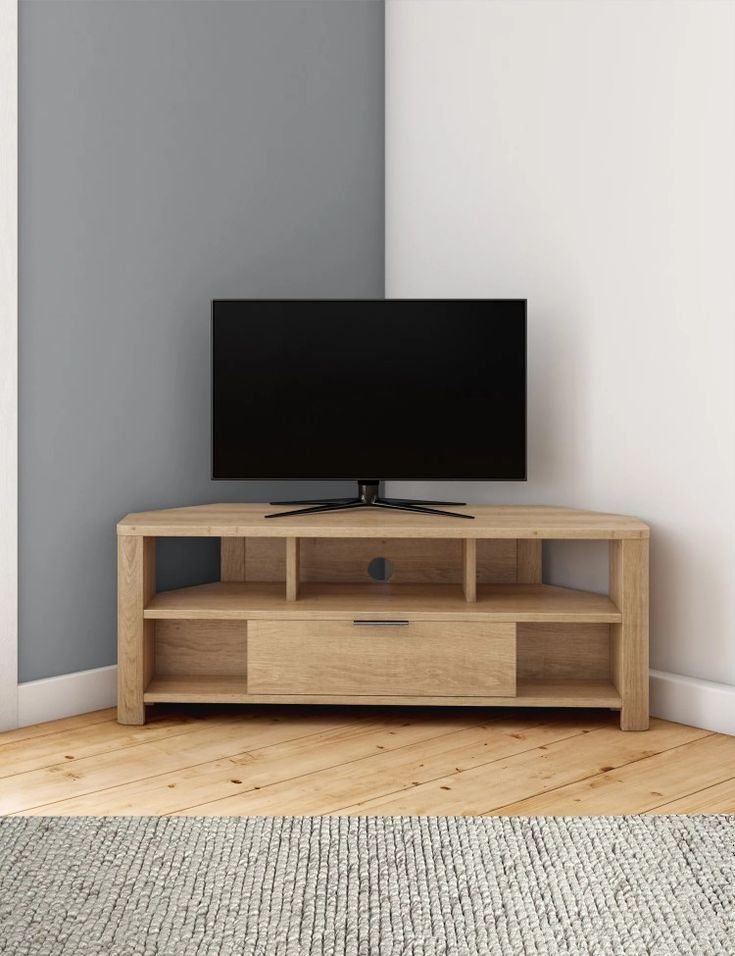 a flat screen tv sitting on top of a wooden stand in front of a wall