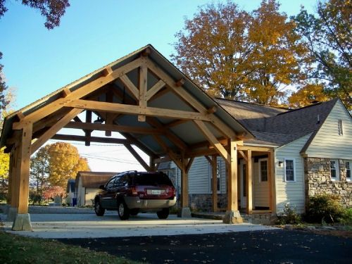 a car is parked in front of a house with an attached carport on the driveway