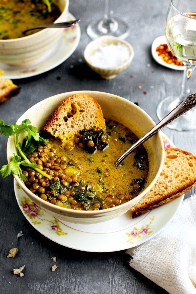 there is a bowl of soup with bread on the table