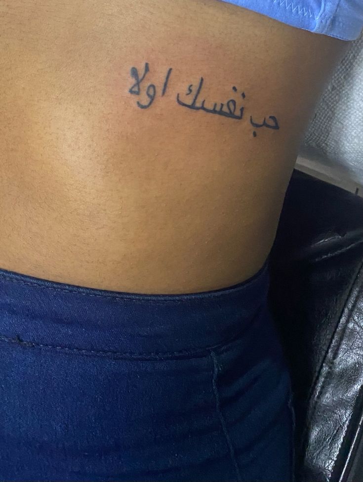 a woman's stomach with arabic writing on the side, and her name written in cursive font