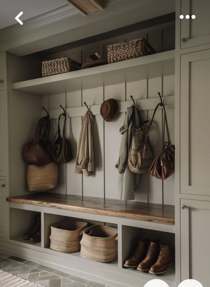 a bench with baskets and umbrellas hanging from it's hooks on the wall