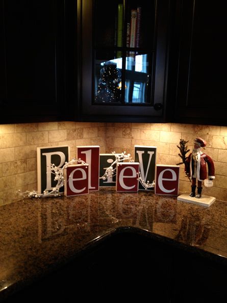 the letters believe are made out of wood blocks on top of a granite countertop