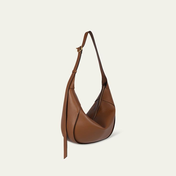 a brown leather shoulder bag on a white background, with the strap hanging down from it's side