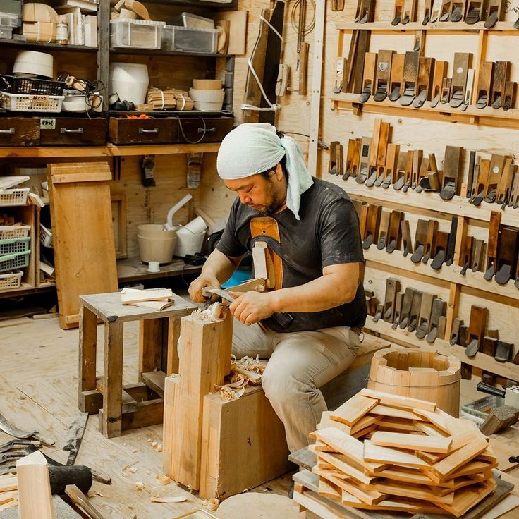 a man working in a wood shop with lots of tools