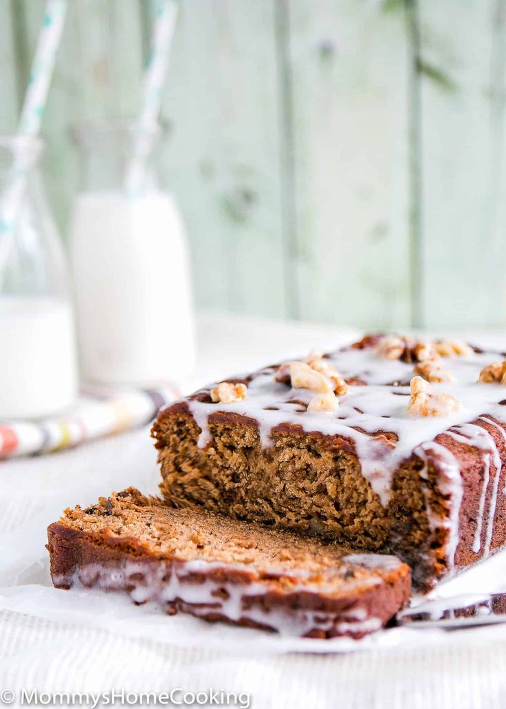 a loaf of cake sitting on top of a white plate next to a glass of milk