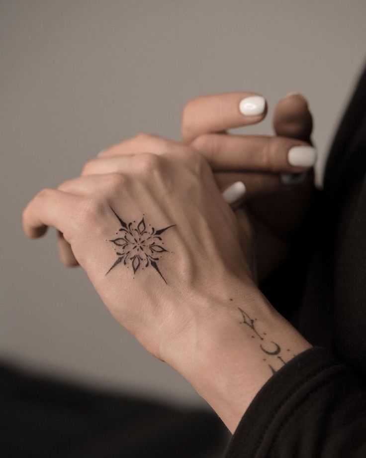 a woman's hand with a small tattoo on it